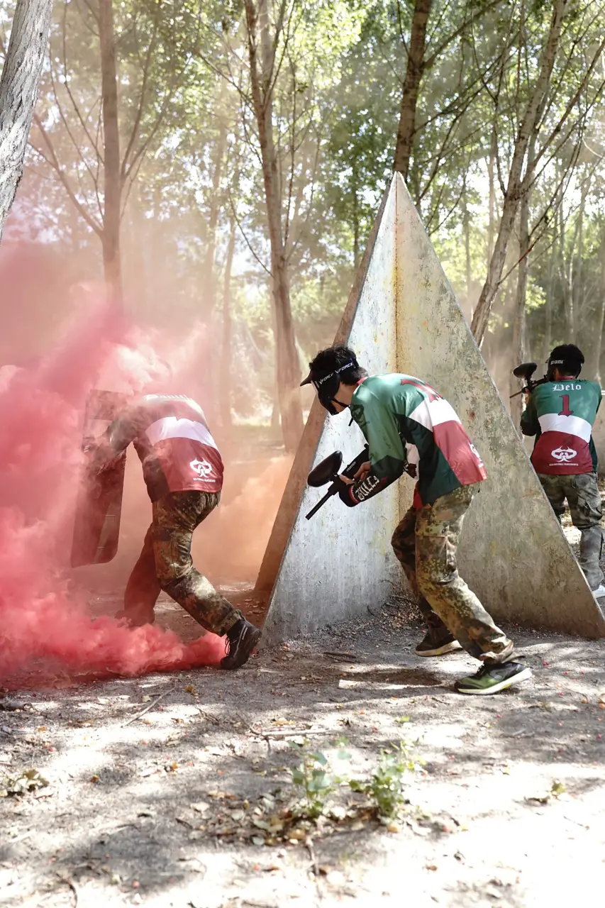 Tre giocatori all'assalto tra il fumo rosso e i ripari triangolari
